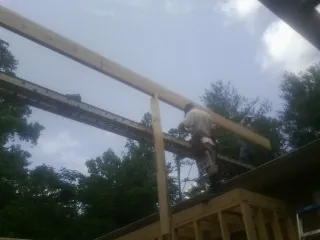 Carpenter setting a ridge beam over a new addition frame — Ice Dam Removal by Roofing Brothers in Almo